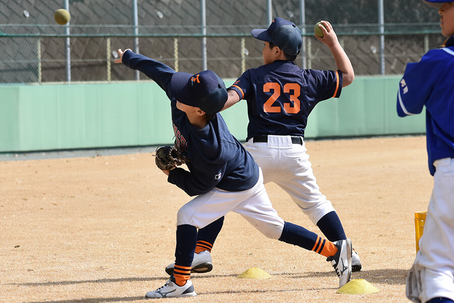 マウンドで投げる少年野球選手