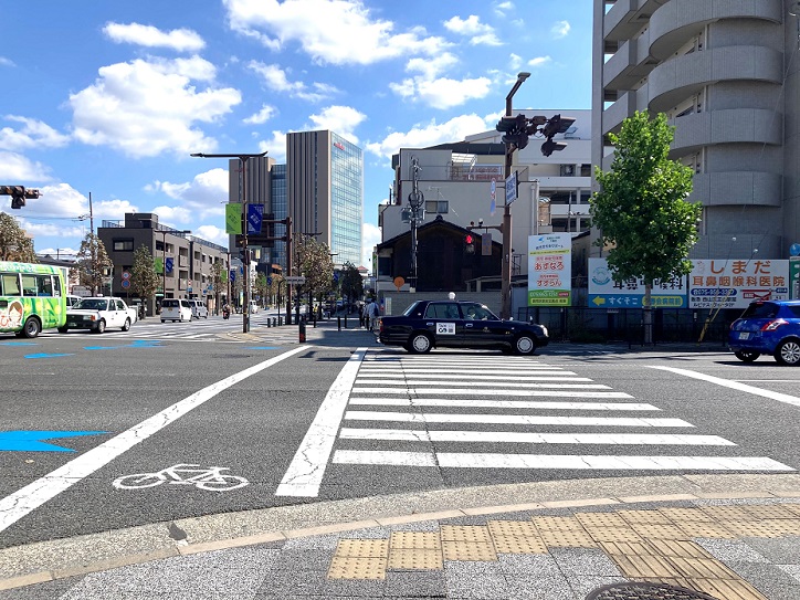{ 大きな交差点の横断歩道を渡り、直進し }