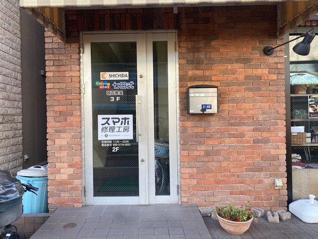 建物の左側に2階へ向かう扉がございます。