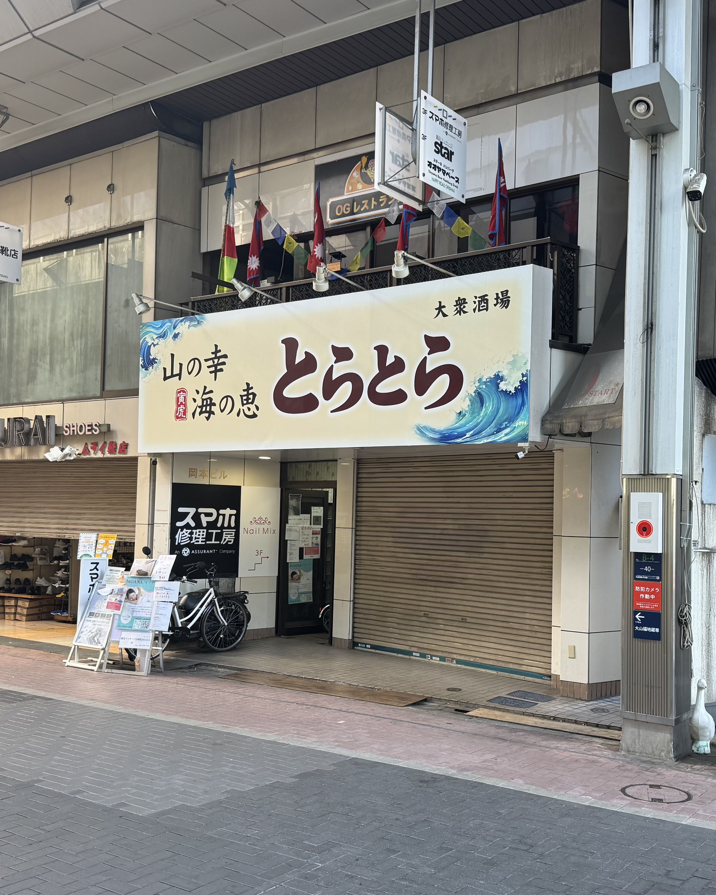 右手に「とらとら」という居酒屋さんが見えてまいります。当店はそのビルの3階になります。