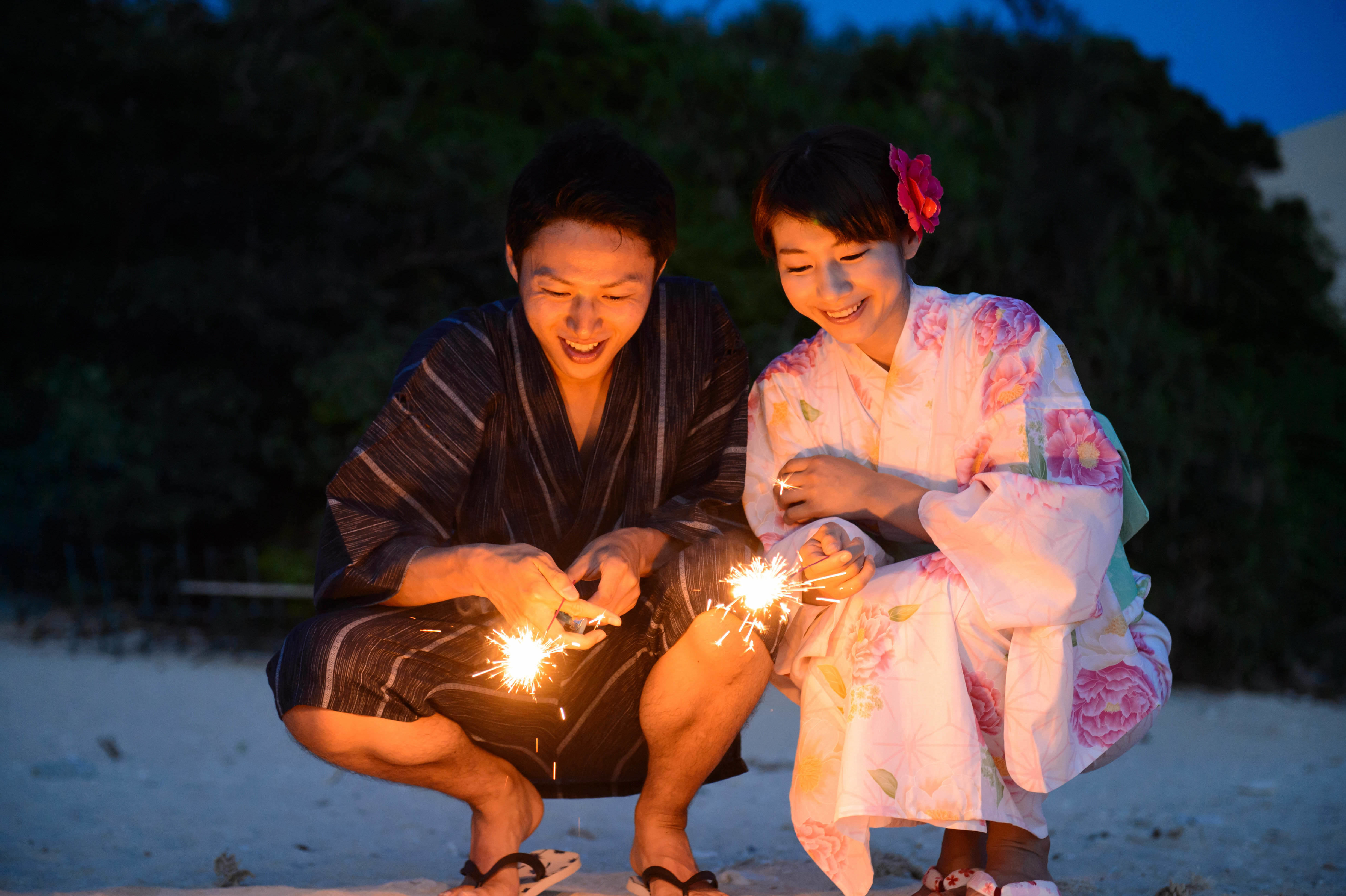 Một cặp đôi đang chơi bắn pháo bông vào mùa hè