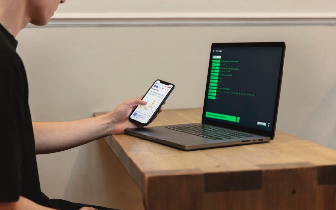 パソコンとスマホで仕事する男性