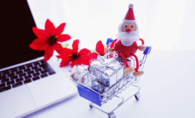 ミニチュアのカートに乗せられたサンタとプレゼント