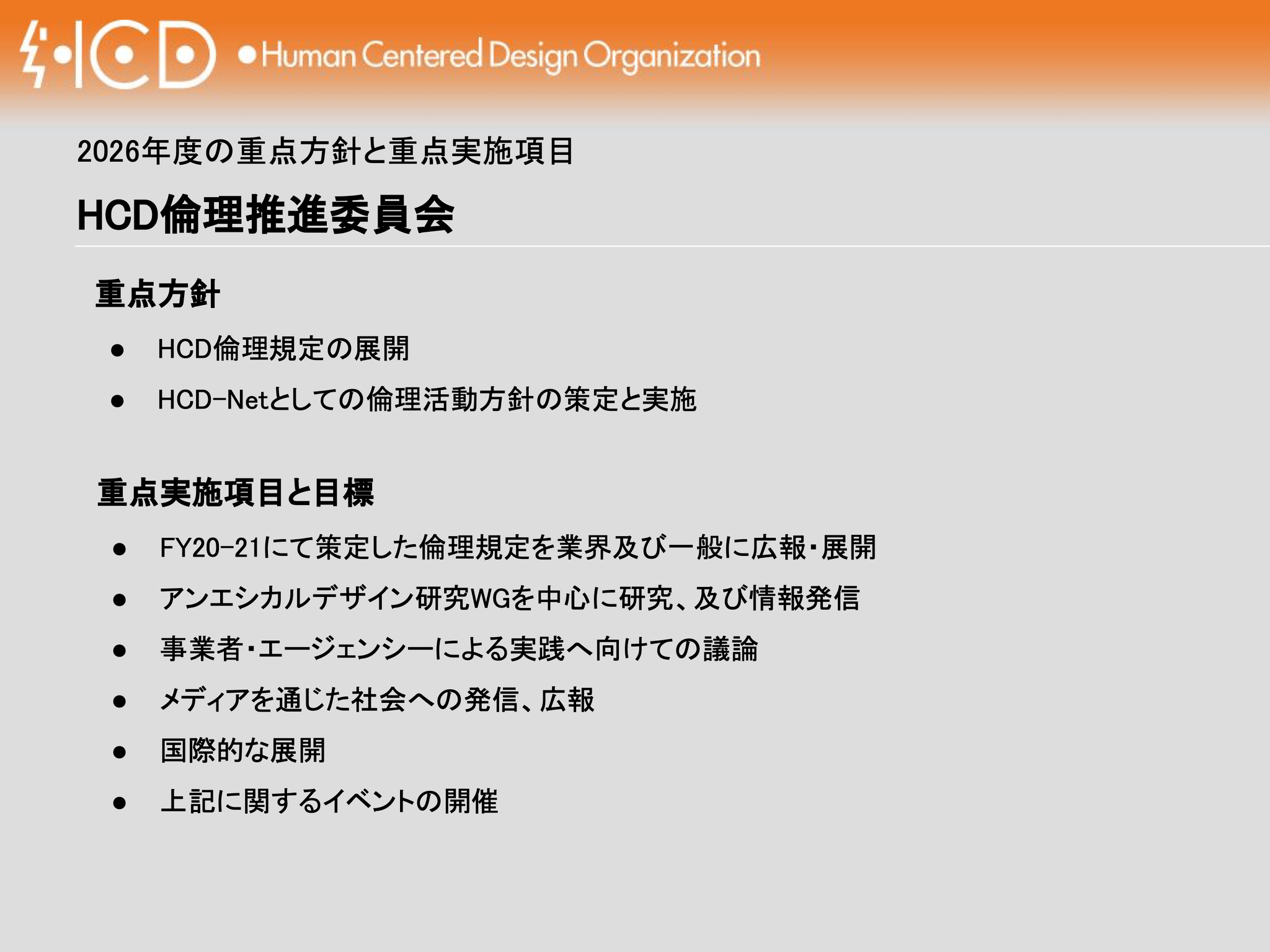 プレゼンテーションスライドの画像です。上部にはオレンジ色の帯があり、左端に「HCD」と稲妻のシンボルを組み合わせたロゴ、その右に「Human Centered Design Organization」と記されています。
中央には「2026年度の重点方針と重点実施項目」および「HCD倫理推進委員会」という大見出しがあり、その下に「重点方針」と「重点実施項目と目標」の2つのセクションが箇造化されて記載されています。それぞれの内容は以下の通りです。
重点方針
HCD倫理規定の展開
HCD-Netとしての倫理活動方針の策定と実施
重点実施項目と目標
FY20-21にて策定した倫理規定を業界及び一般に広報・展開
アンエシカルデザイン研究WGを中心に研究、及び情報発信
事業者・エージェンシーによる実践へ向けての議論
メディアを通じた社会への発信、広報
国際的な展開
上記に関するイベントの開催