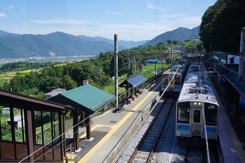 スイッチバックとともに交換が行われる姨捨駅 E127系の普通列車同士が行き違う
