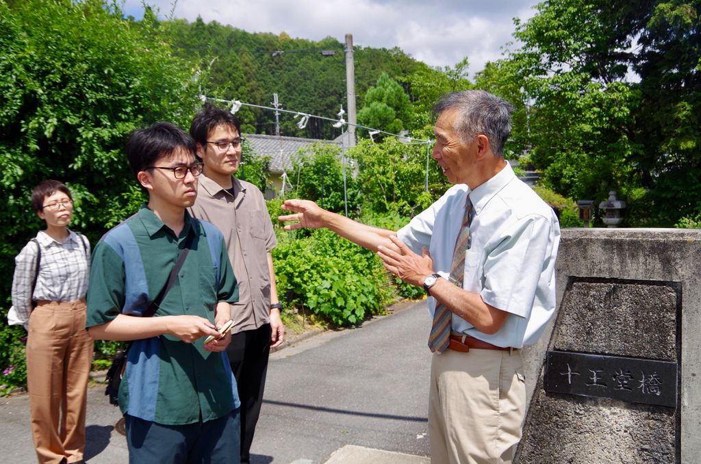 地域の歴史を解説する中村先生。目の前に広がる風景と照らし合わせながら、岩倉の歩みをたどります。