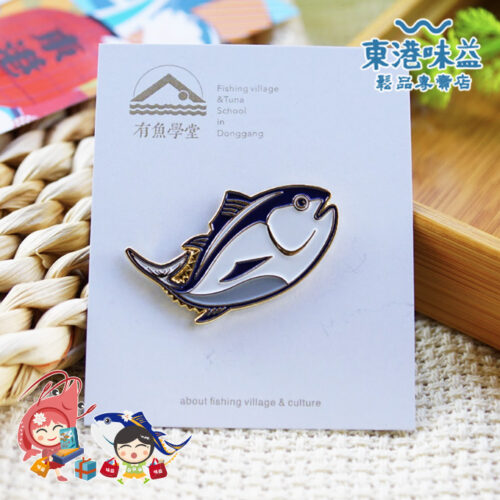 東港文創美感徽章是榮獲**「屏東十大文創」認證的指標性商品。該系列以屏東黑鮪魚為設計核心，融合現代美學工藝，是國內外旅客走訪東港時最具代表性的必買文創紀念品與文化伴手禮**。